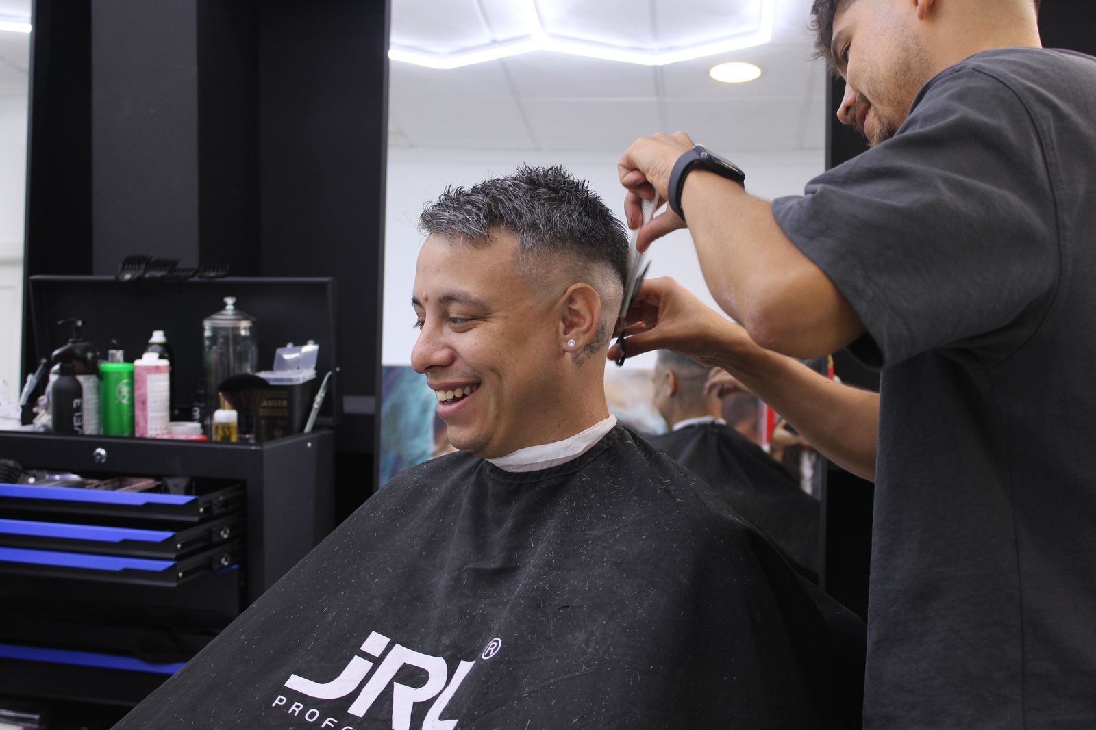 Barbero de Barberland Premium aplicando los últimos detalles a un corte con degradado