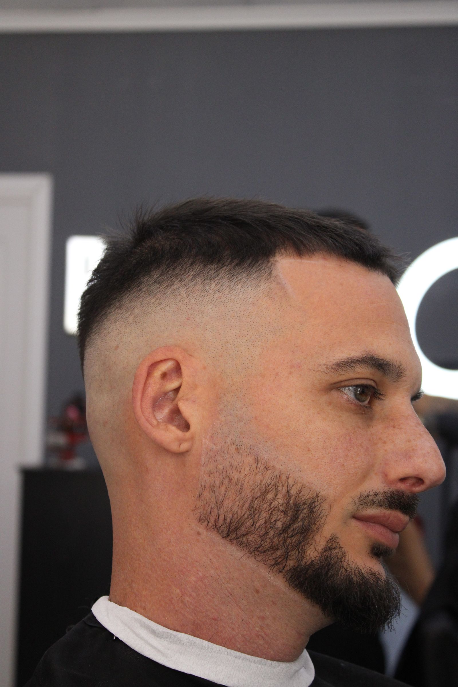 Barbero y cliente sonriendo durante una sesión de corte