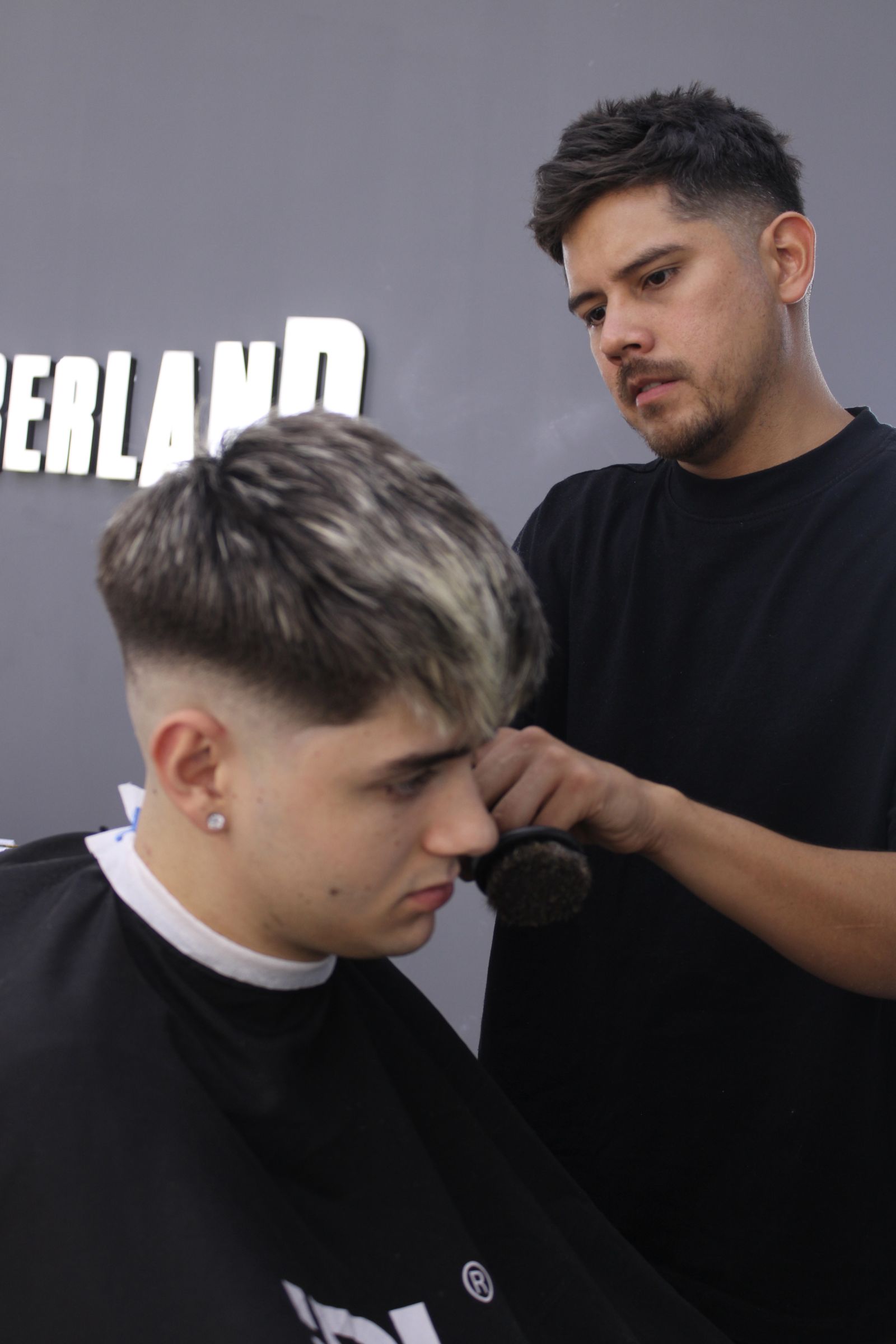 Perfil de un corte degradado terminado, cliente sonriendo