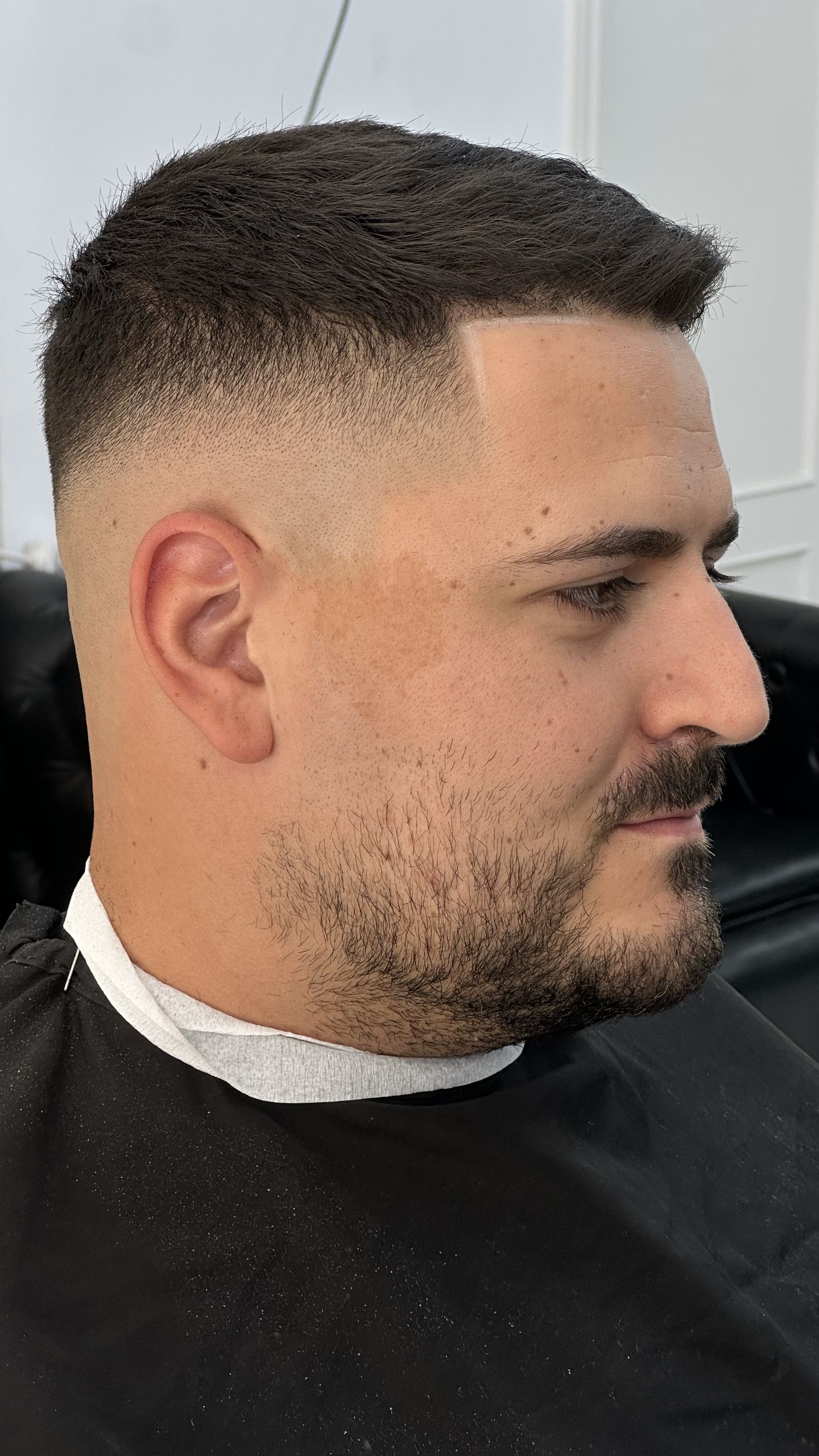Barbero aplicando producto con peine a un cliente