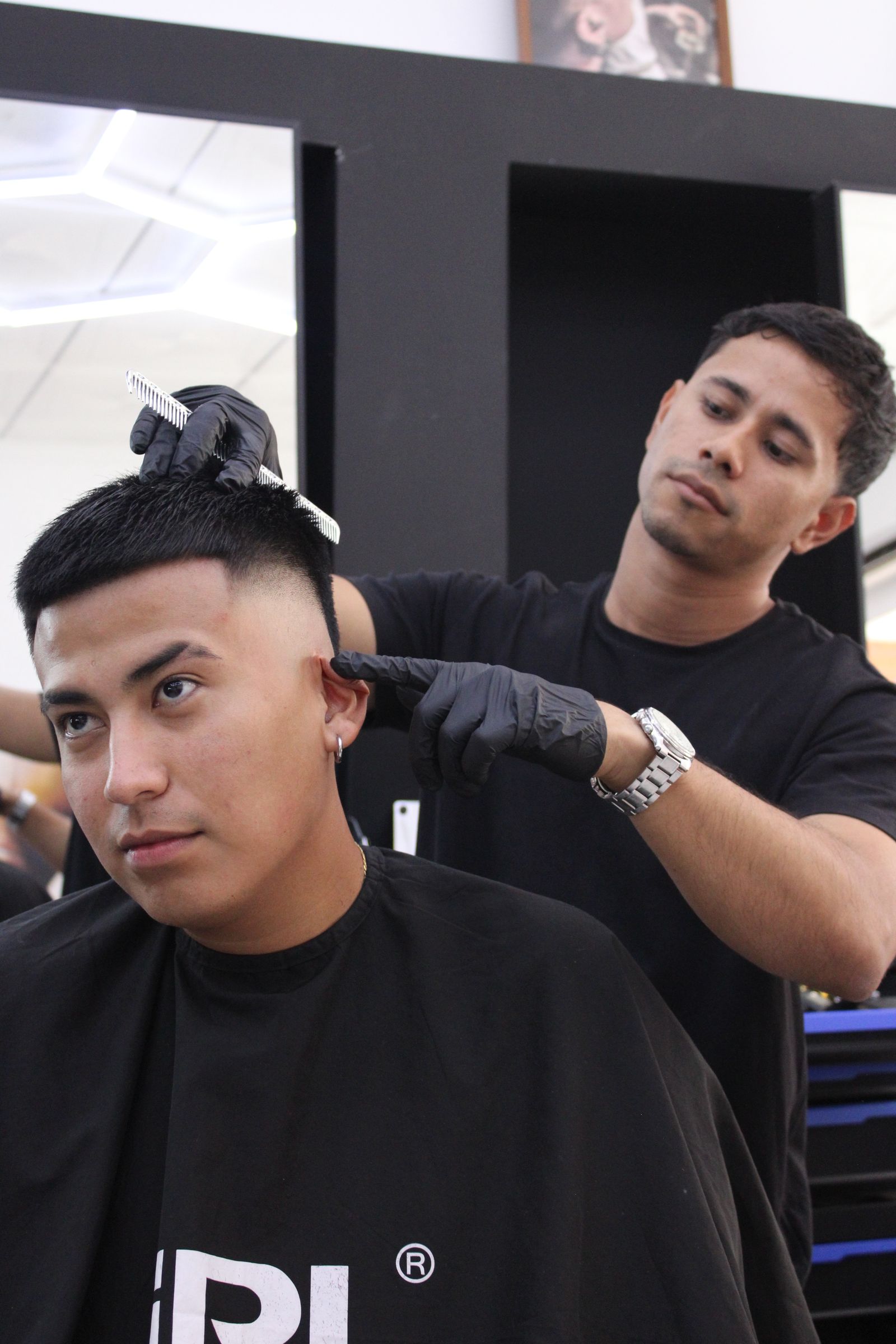 Barbero de Barberland Premium aplicando producto con guantes a un cliente